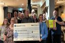 Dave Saunby (centre) and members of theMartin Jennings Marshals Association) present the cheque toClaire Frost (right), Cornwall and Devon fundraiser for the Alzheimer's Society,