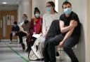 People wearing masks waiting to get their vaccine. Credit: PA