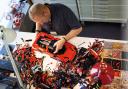 A man assembling LEGO's new Technic Ferrari Daytona SP3. Credit: LEGO