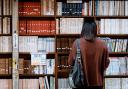 A student browsing books in the library. Credit: Canva