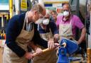 The Prince of Wales uses a lathe during a visit to Faithworks Carpentry Workshop