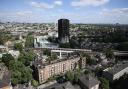 A tube train passes the remains of Grenfell Tower