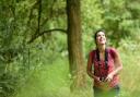 Woman birdwatching and exploring woodland, Sherwood Forest National Nature Reserve, Nottinghamshire, July