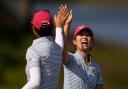 United States’ Rose Zhang, right, is congratulated by Andrea Lee after hitting out of a bunker and into the cup on the 13th (Matt York/AP)