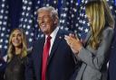 Republican presidential nominee former President Donald Trump stands on stage with former first lady Melania Trump, as Lara Trump watches, at an election night watch party at the Palm Beach Convention Center, Wednesday, Nov. 6, 2024, in West Palm Beach,