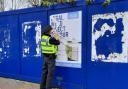 Police remove a poster in Bournemouth town centre