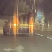 A man firing a catapult from a moving car