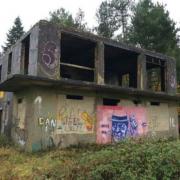 The control tower is derelict and covered in graffiti, including an image of Winston Churchill