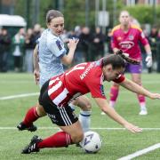 Lucy Cooper battles for the ball