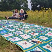 Project leaders Lara Kynvin and Beeb Deacon with the suicide memorial quilt that will be unveiled today