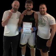 Sam Carr receiving his certificate of Home Counties Championship with boxing coaches Jason Barker on the left and Head Coach Joe Hayes on the right.