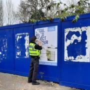 Police remove a poster in Bournemouth town centre