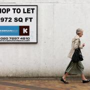 A woman makes her way past an empty shop in Stockport. The number of vacant shops blighting the UK's high streets and shopping centres has continued to rise, a report revealed today, amid grim warnings that some will never fully recover.