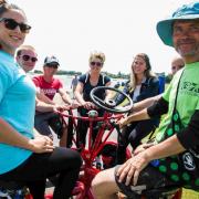 Mickey Storey, right, takes Poole Park visitors for a ride on a seven-seater Conference bike for Borough of Poole's Bike Day, publicising the Momentum Cycle Challenge