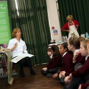 Pupils at The Priory School get involved in cooking at the school as part of the Christchurch Food Festival Education Trust programme. Pictured is Mary Reader, president of the festival, with year five pupils.