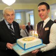 Former Bournemouth Rotary president John Bowen is presented with a Rotary cake to mark his 103rd birthday