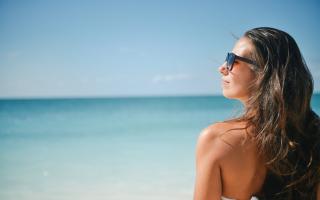 A woman standing in front of the sea. Credit: Canva