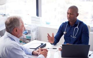 A doctor speaking with a patient. Credit: Canva