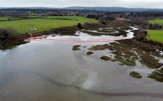 The clean-up operation involving booms after the oil leak in Poole Harbour