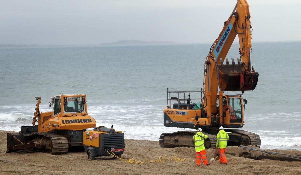 The 700m pipe used to protect Poole's beaches from coastal erosion after the winter storms is removed from Canford Cliffs. Photos by Sally Adams. 