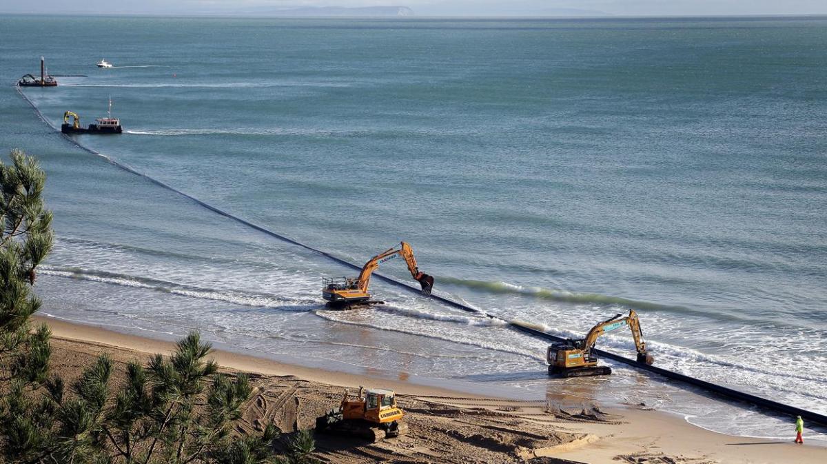 The 700m pipe used to protect Poole's beaches from coastal erosion after the winter storms is removed from Canford Cliffs. Photos by Sally Adams. 