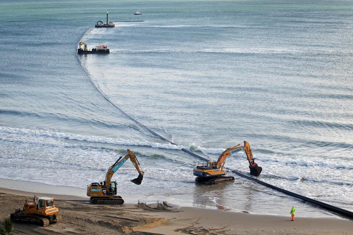 The 700m pipe used to protect Poole's beaches from coastal erosion after the winter storms is removed from Canford Cliffs. Photos by Sally Adams. 