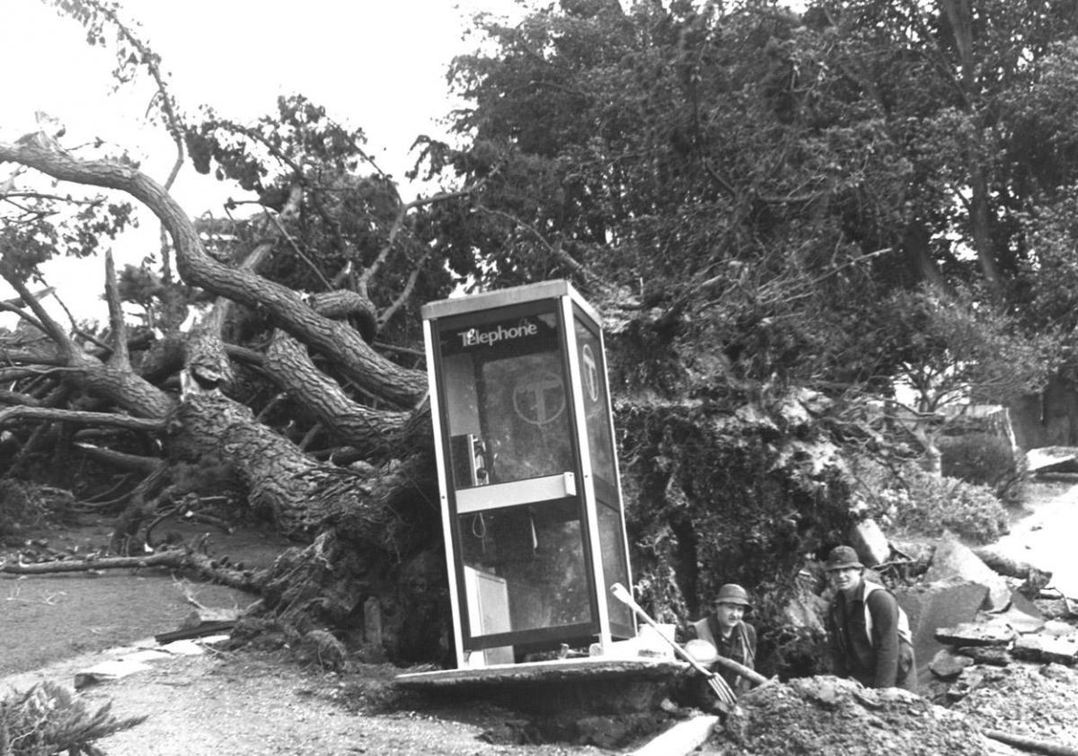 Wessex Water workmen battle round a telephone box to repair a burst water main in Mudeford in wake of a great storm in 1990
